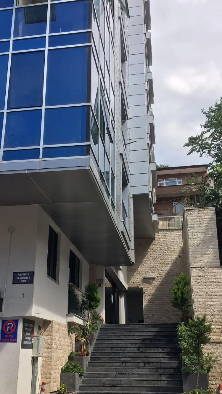 Rozehill Residence’ın taş duvarlı giriş merdiveni ve blok tabelası