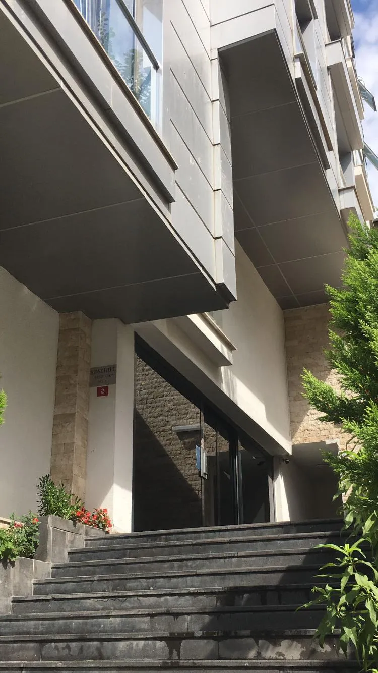 Rozehill Residence’ın bina girişi, merdiveni ve çiçekli peyzajı